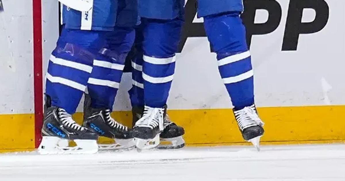Hockey players' skates are seen on the ice. 