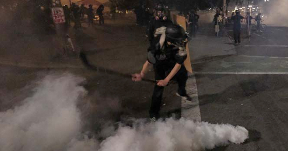 Protester uses hockey stick to slapshot tear gas canister at Portland police